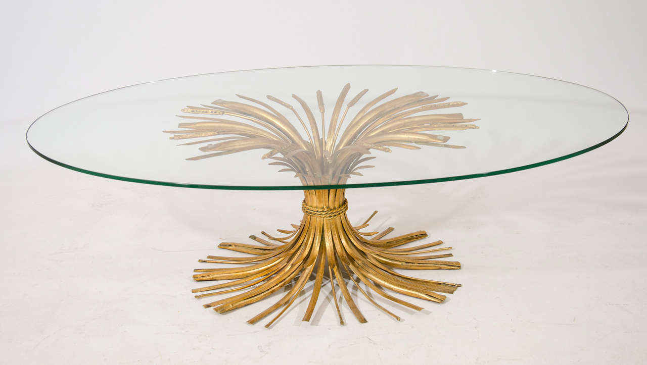 Lovely oval coffee table with a gracefully formed base of gilt tole.