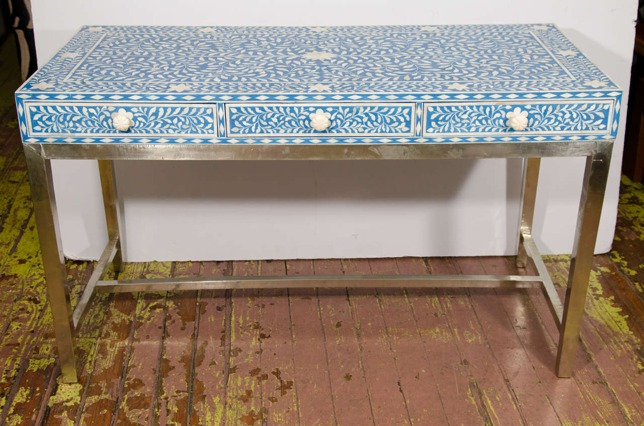 Inlaid bone desk with 3 drawers and bone knobs with a white metal base.