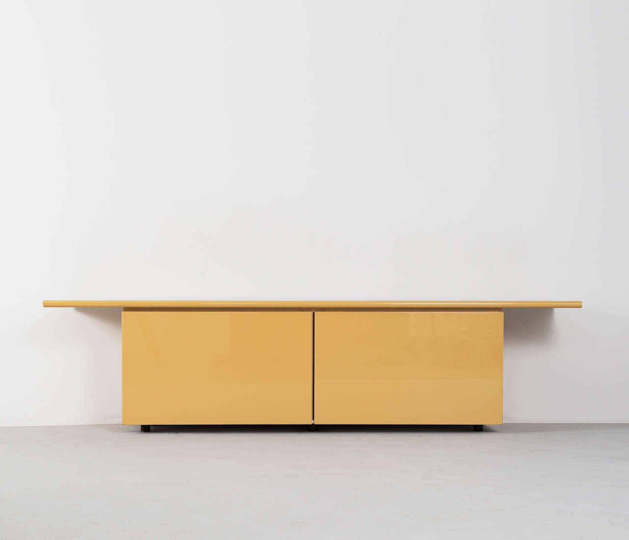 Stunning italian credenza with oversized top in high gloss pastel yellow, designed by Giotto Stoppino. The sideboard is provided with an innovated design, with roll doors that pivot for access to four drawers and various shelves.

Elegant