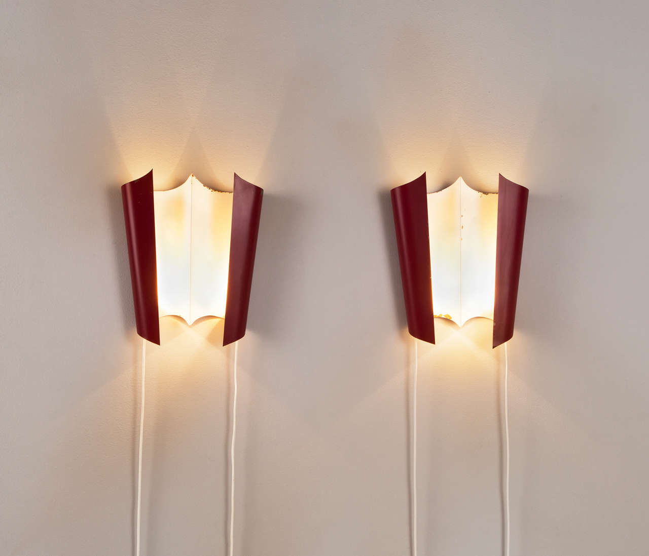 Set of two wall lights, in metal, for Stilnovo, Italy, 1950s.

Excellent pair of wall lights with very nice and elegant shape and light spreading.
Produced by Stilnovo. The red coated frame is in nice contrast with the white inside. Both show