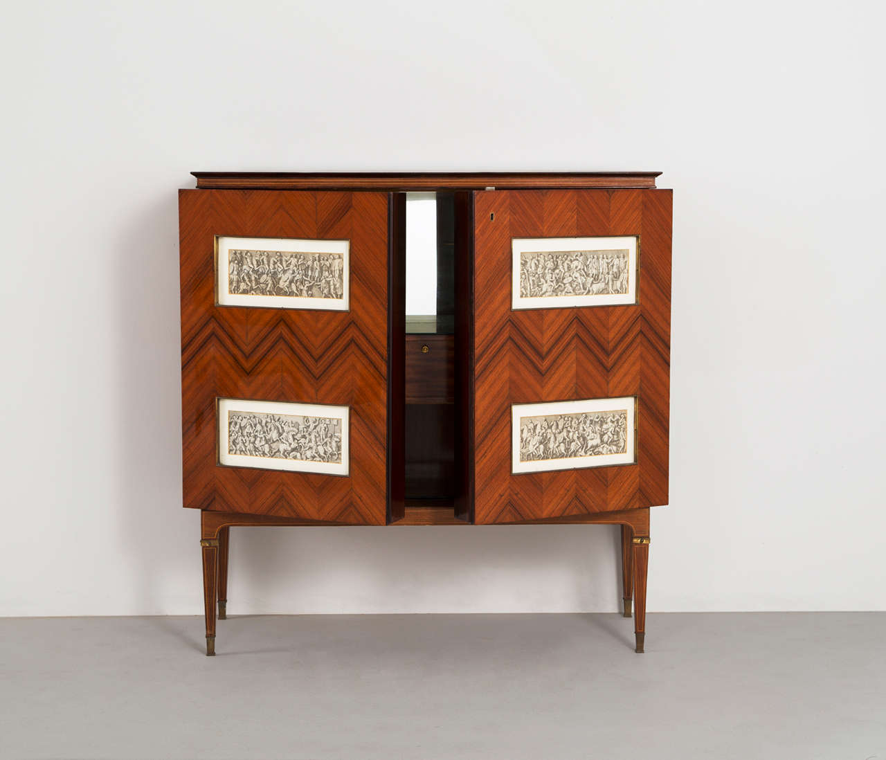 Dry Bar Cabinet, in rosewood, brass and glass, by Paulo Buffa, Italy, 1940s. 

Large liquor cabinet by Paulo Buffa. The bar rosewood veneer and features spectacular herringbone illuminated prominent doors which are recessed with four gold leaves
