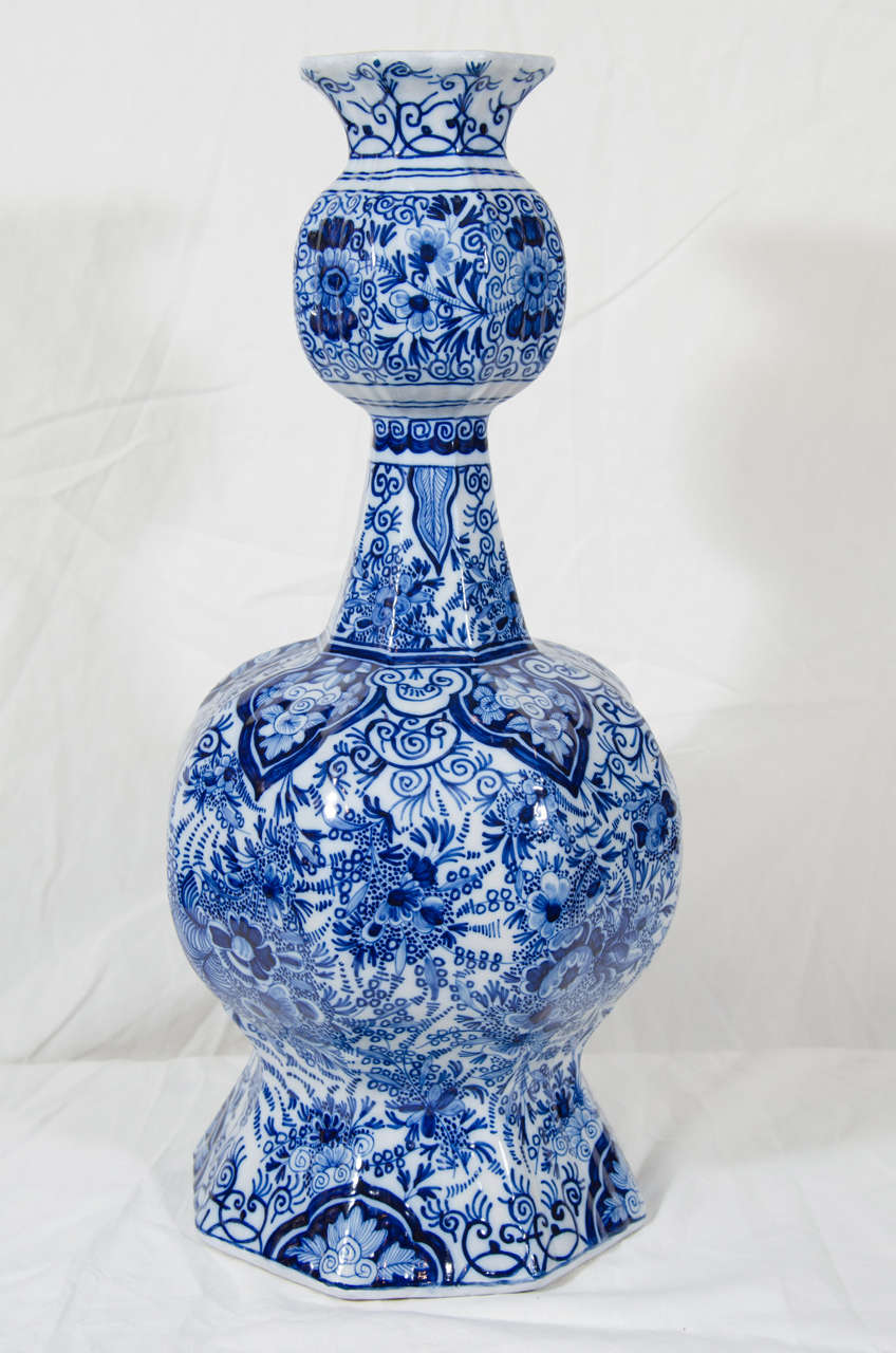 A pair of Dutch delft Blue and white vases with an all-over design of peonies and other flowers. The shoulders have bands of lappets and scrolling vines.