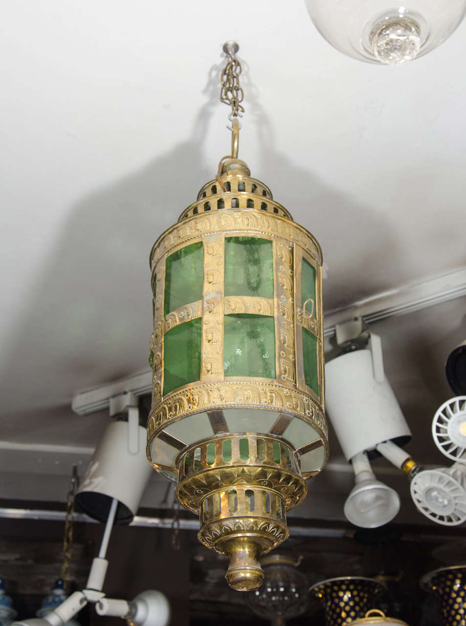A large Dutch ship's hanging lantern handcrafted of pierced metal, circular in form with repousse decoration and fitted with green glass panes. The lantern holds eight green glass panels around the side and eight smaller panels around the bottom of