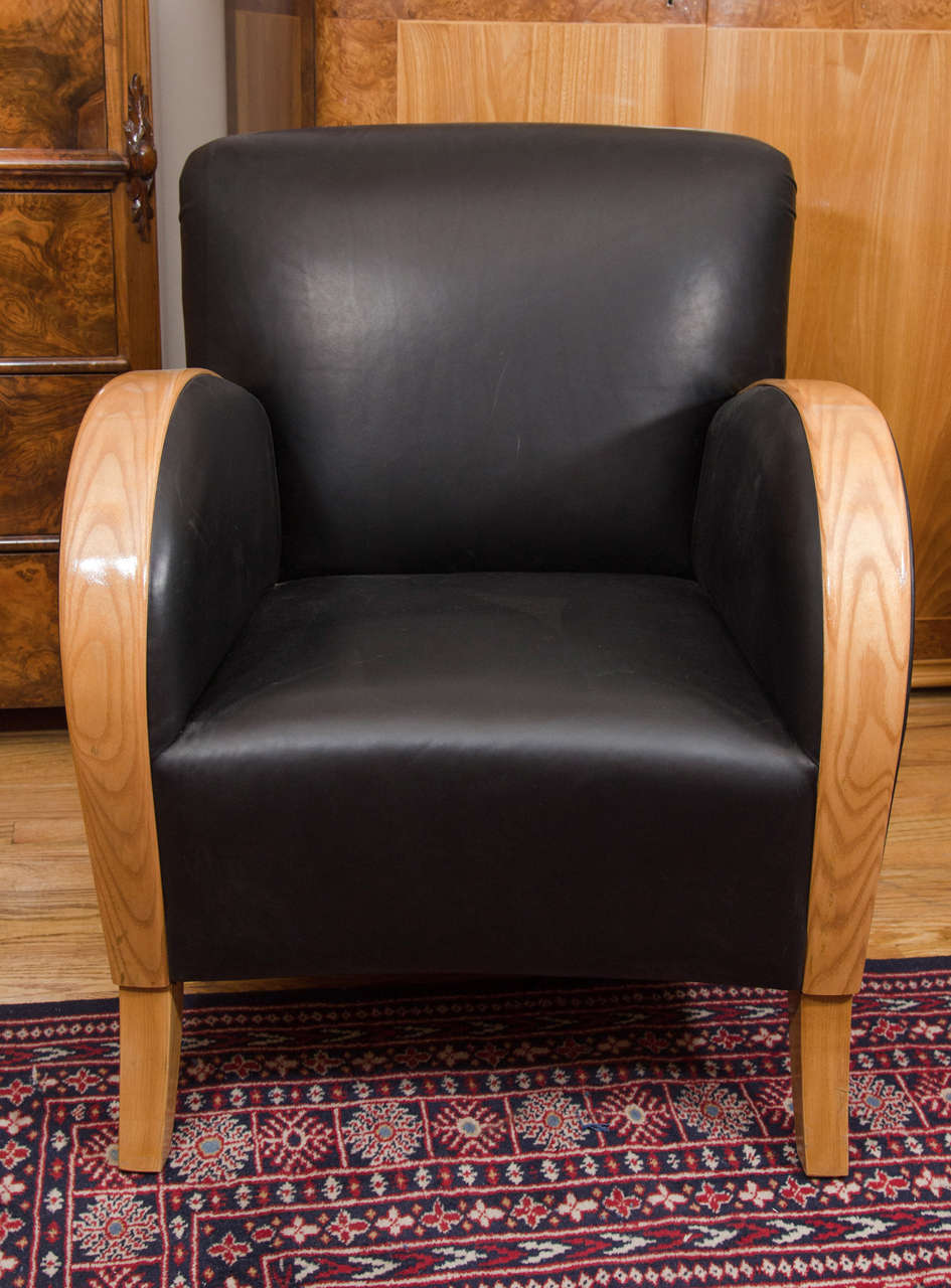 Somewhat larger than the typical Swedish club chairs, this comfy, yet serious chair has curves in all the right places. Upholstered in nearly indestructible black motorcycle leather, the contrasting golden wood is crafted of solid bent birch.