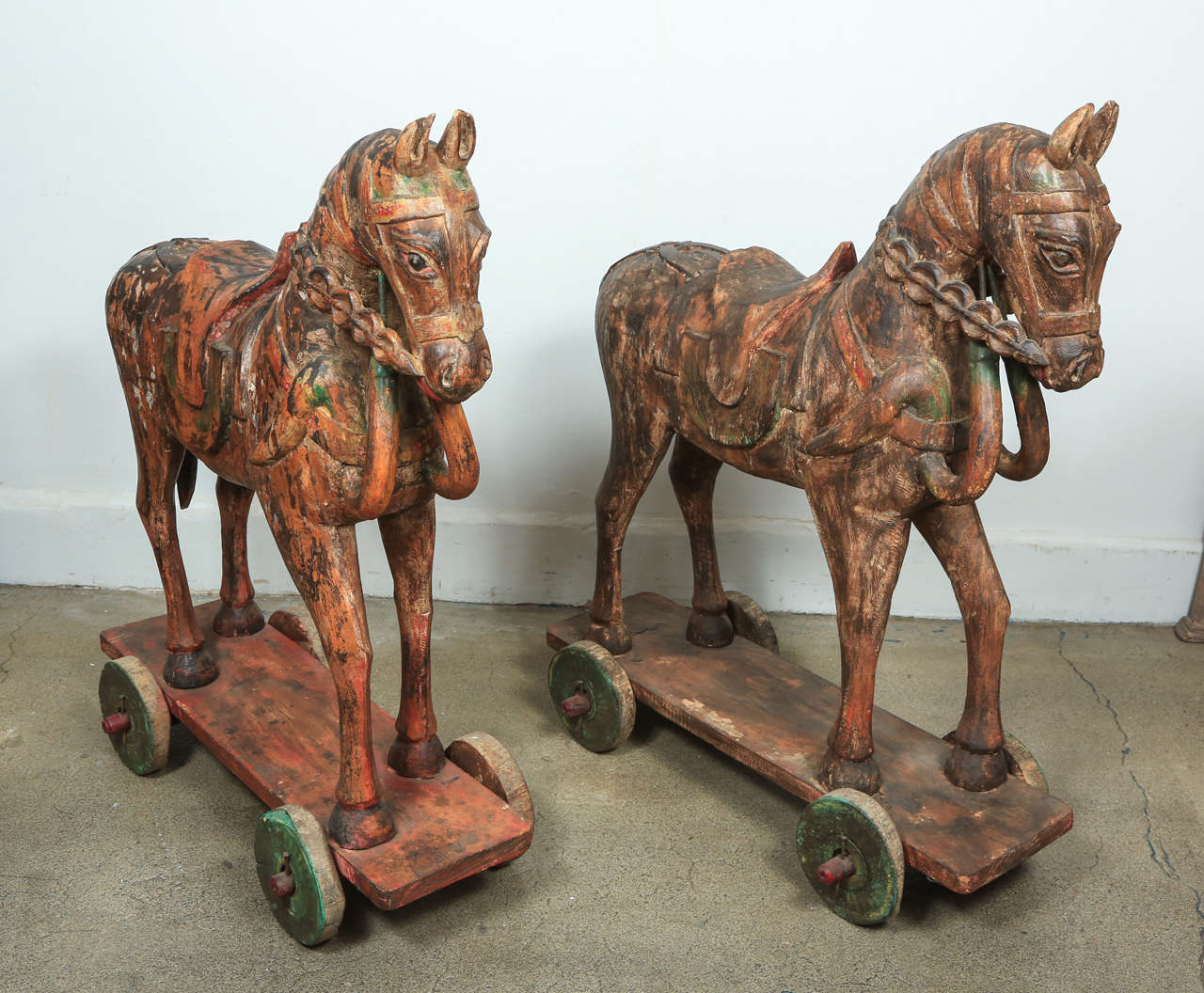 Pair of hand-carved wooden Anglo-Indian temple horses with poly-chrome decorated sitting a top of a wheeled board.
The two horses are almost the same size, but different designs, carving and colors, they are not matching.
Very nice handicraft,