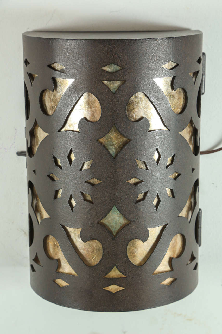 Four Moroccan Spanish style iron sconces designed and manufactured by Paul Ferrante of Los Angeles.
Hispano Moresque style in iron with a dark finish patina, the inside is lined with faux parchment and it is wired with two candelabra lights 60