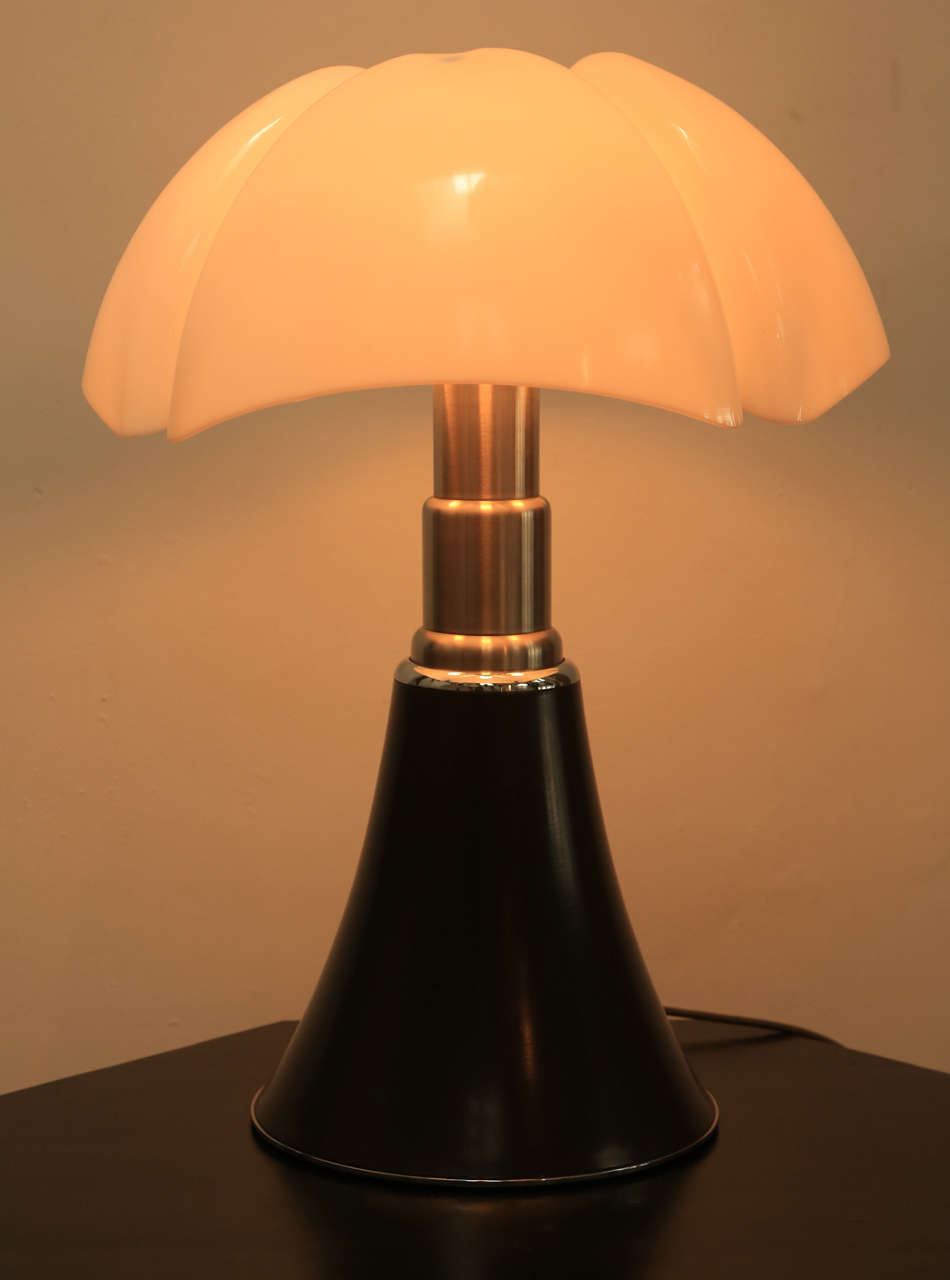 The classic icon lamp of the 20th century designed by Gae Aulenti in 1965 for Martinelli Luce, Italy. White opal methacrylate shade offers diffuse light and is centered by a black round ball finial. The base consists of a very solid, adjustable