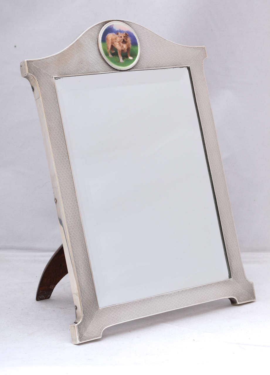  Art Deco, rare and unusual, sterling silver, engine turned table mirror (with original beveled mirror), having an enameled plaque of a Norwich Terrier centrally placed on the upper part of the sterling silver frame of the mirror, Birmingham,
