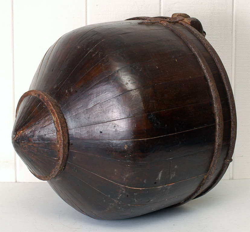 Chinese elmwood water bucket with original iron hardware. Unusual pointed bottom causes a rocking motion. Perfect as a firewood container or magazine organizer.