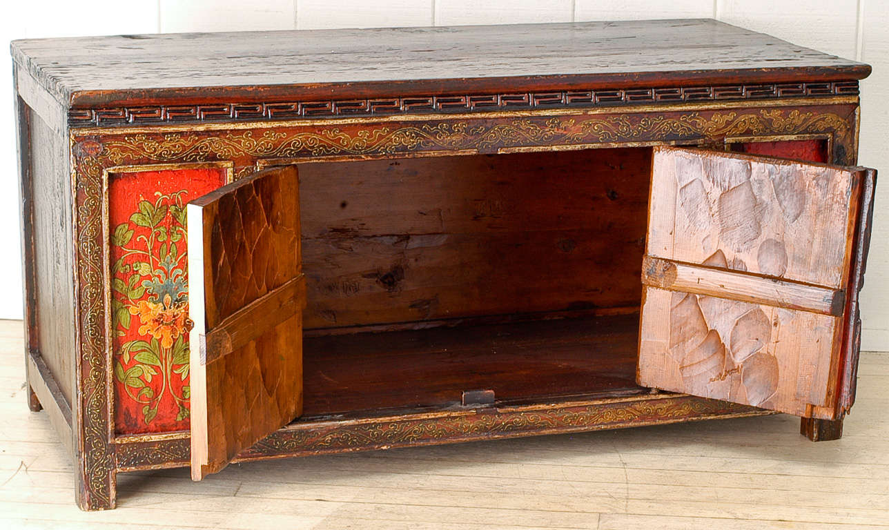 Authentic Low Cabinet from Tibet. Hand hewn and hand painted in subtle polychrome hues imbued with an overall patina of generations of use.Interesting room accent which offers storage. Can be used as a coffetable, trunk or even bench.
