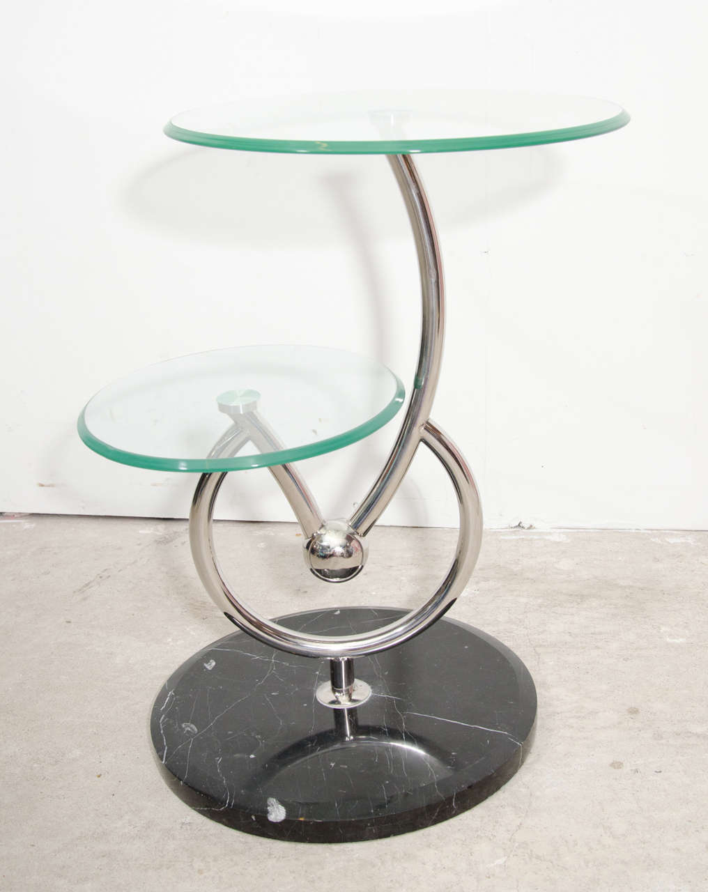 Beautiful modern two tier side table with a black marble base and steel branches holding two circular glass.