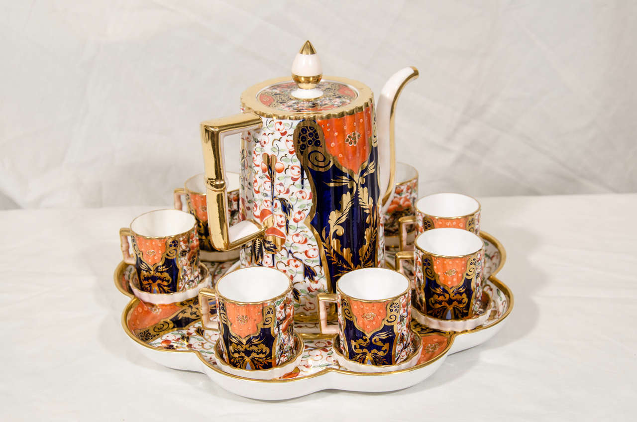 An English demitasse set lavishly decorated in the Imari palette of iron red, cobalt and gold with touches of green.
The set includes 8 demitasse cups with individual saucers, a coffee pot with cover, and a lobed serving plate to hold it all.
With