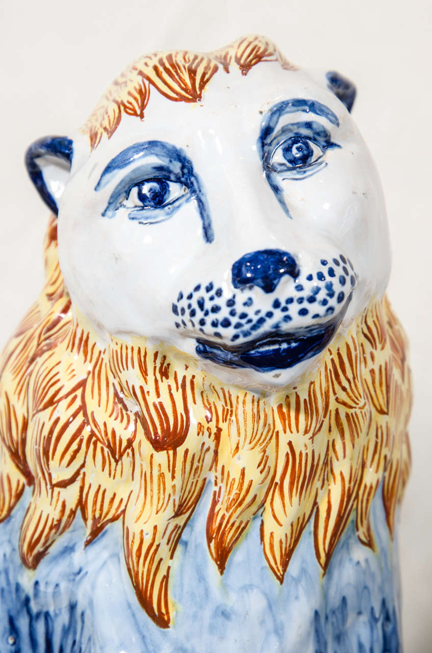 French A Pair of Antique Faience Lions Painted in Polychrome Blue and Yellow