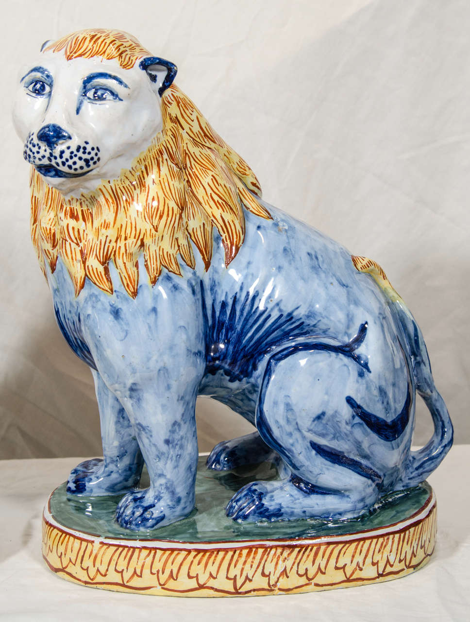 A Pair of Antique Faience Lions Painted in Polychrome Blue and Yellow In Excellent Condition In Katonah, NY