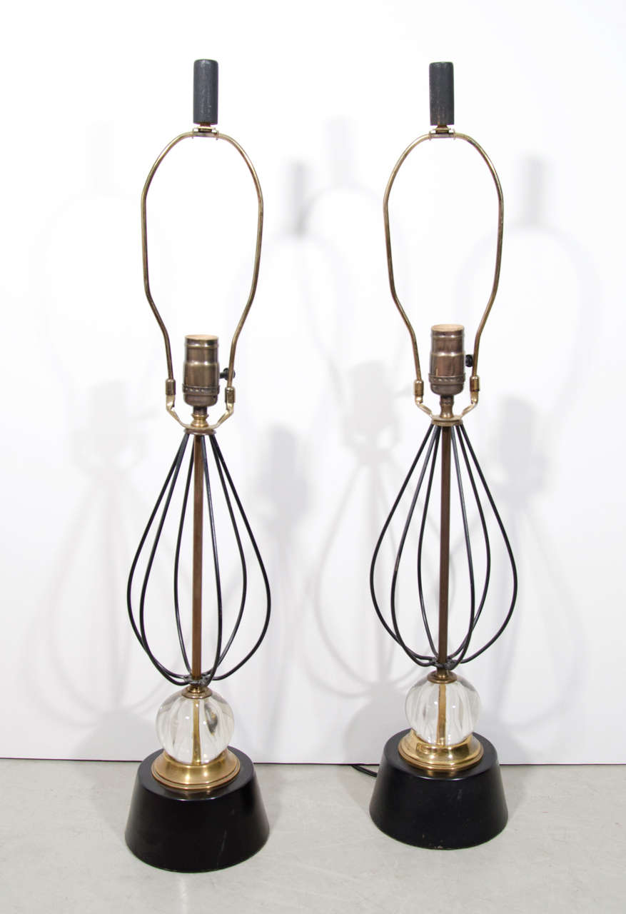A beautiful pair of tables lamps, without shades. A wire cage body sits atop a round crystal, brass and painted metal base.
Original wooden finials. Rewired.