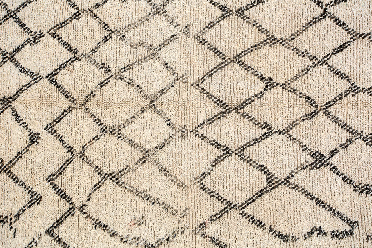 Moroccan vintage Berber rug from the Beni Ouarain tribes. 
Lush white and black organic wool rug with geometrical lozenges designs.
Dark black abstract designs in lozenges on a natural cream field lush lamb un dye wool.
Very interesting modernist