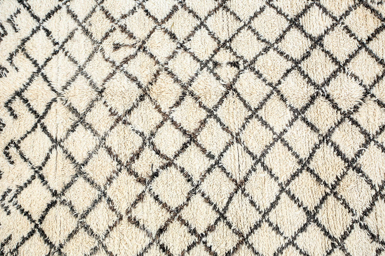 Moroccan Berber rug from the Beni Ouarain tribes. Lush white and black organic wool rug with geometrical lozenges designs. From the Middle Atlas Mountains. Circa 1950's.  North Africa.
Dark black abstract designs in lozenges on a natural cream field