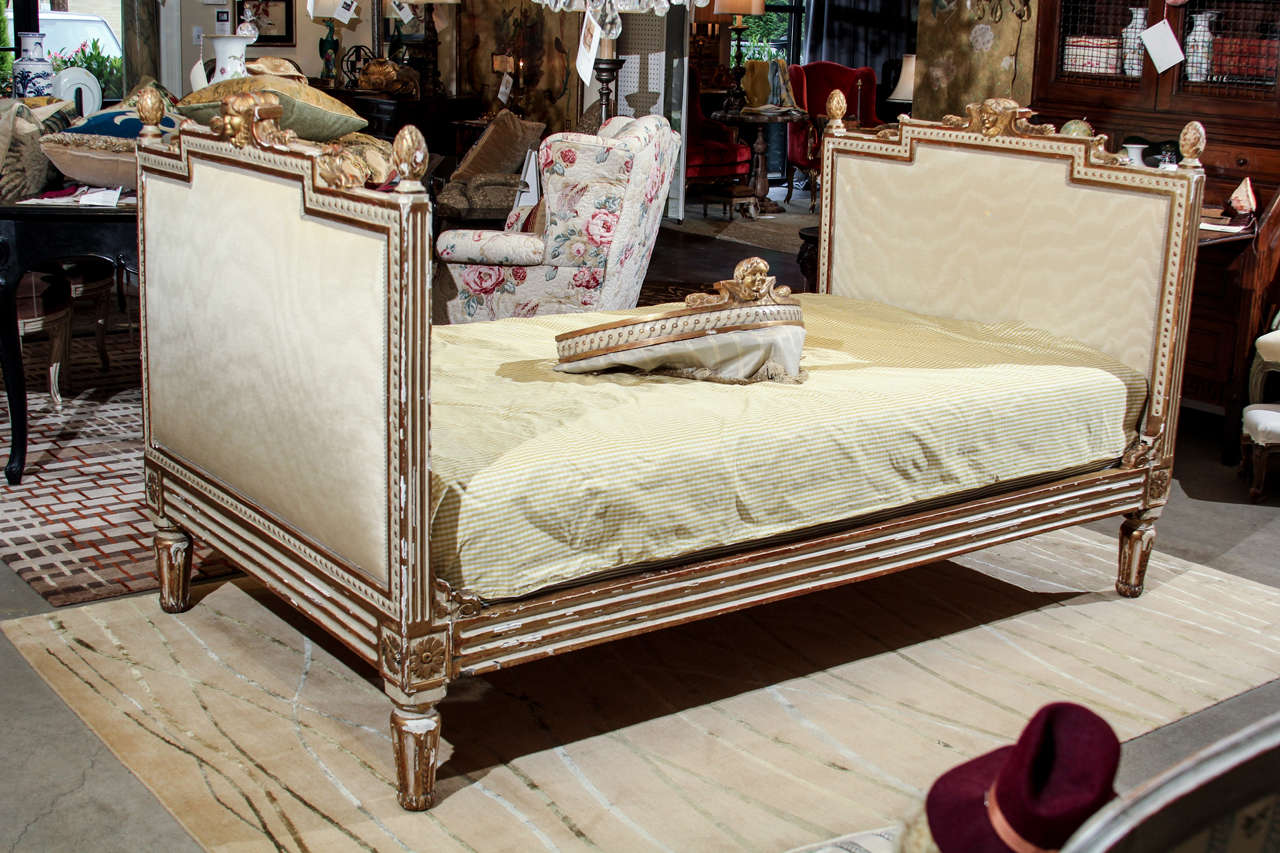 An early 19th century Italian carved, painted and gilt Italian daybed with matching corona