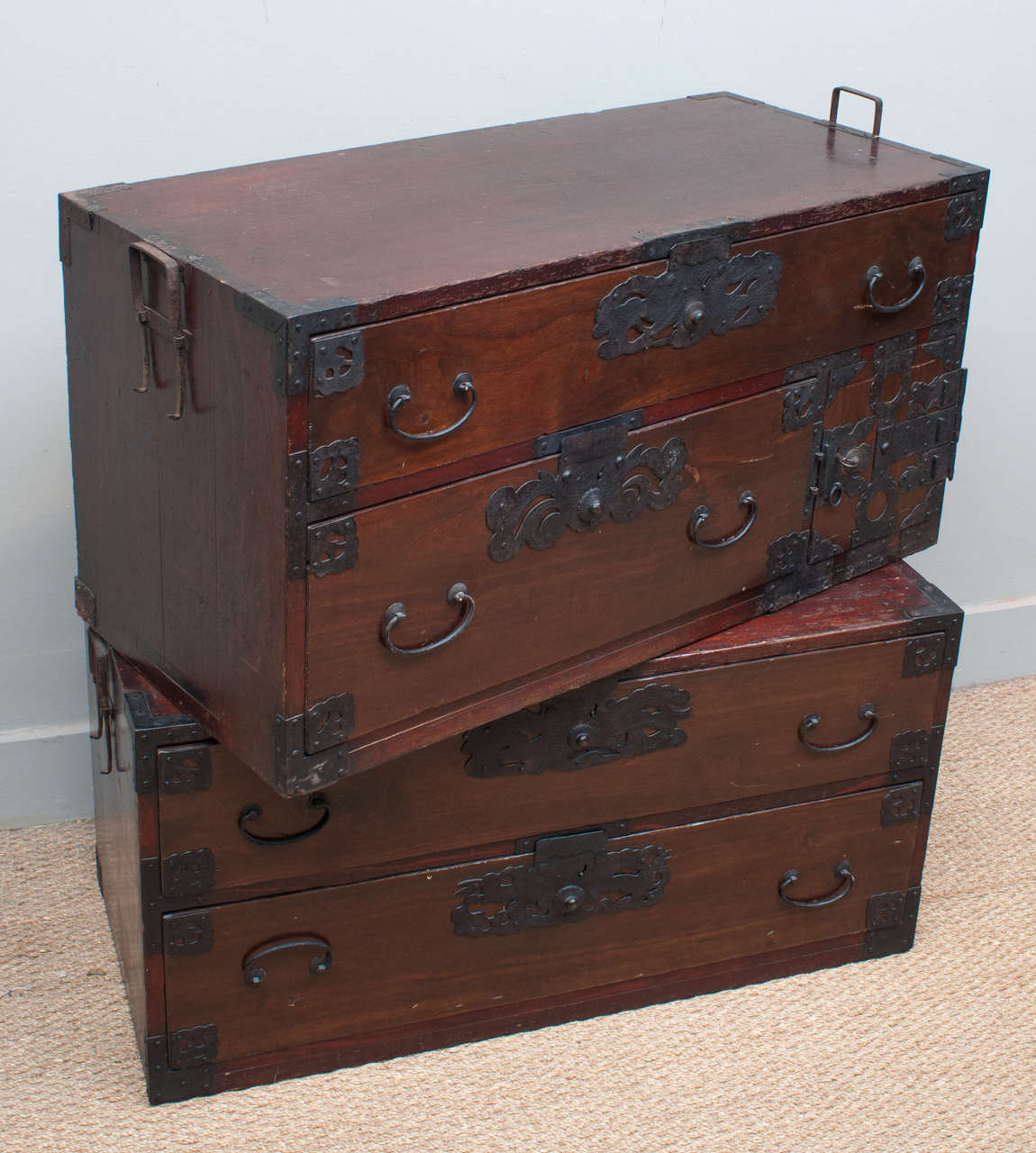 Striking two section, kiri wood tansu with hand forged iron and bronze decorative hardware. chest offers four storage drawers plus locked compartment for valuables.