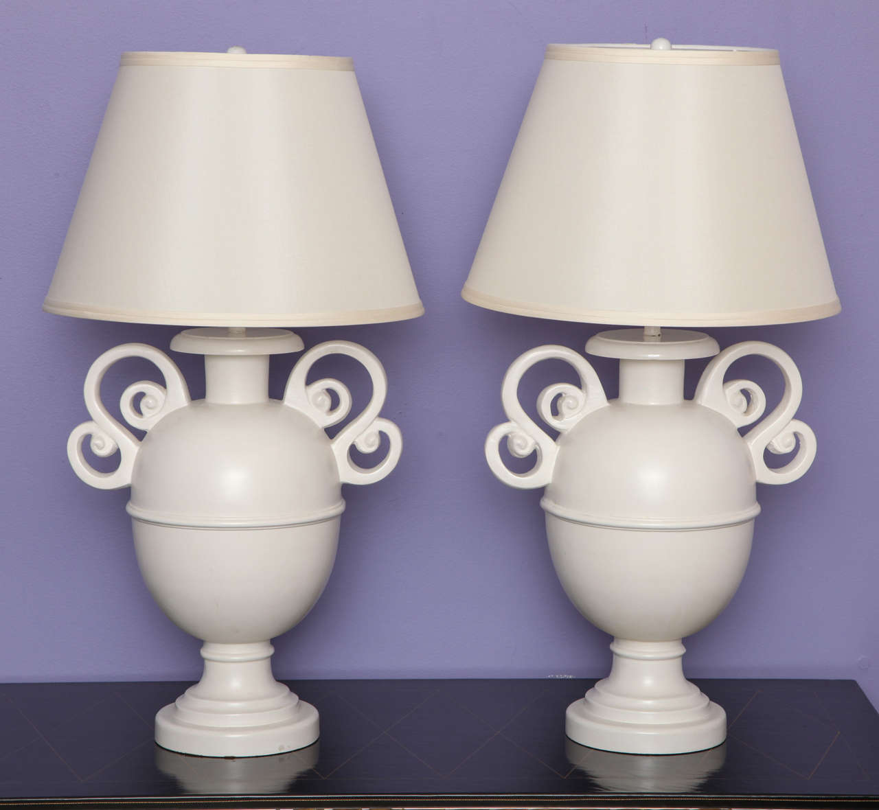 Pair of urn form lamps with scrolling handles painted in a glossy white finish. 
American, c. 1970