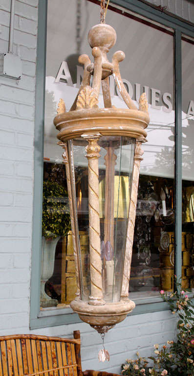 These long and lovely wood lanterns have four columns and a gold and grey patina. All of the decorative wood pieces are antique. The glass and electrification are contemporary.