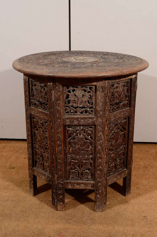 The top with a center roundel with a floral design of inlaid bone.
The roundel surrounded by two friezes of carved grapevines and vines and flowers.  The top on a similarly carved