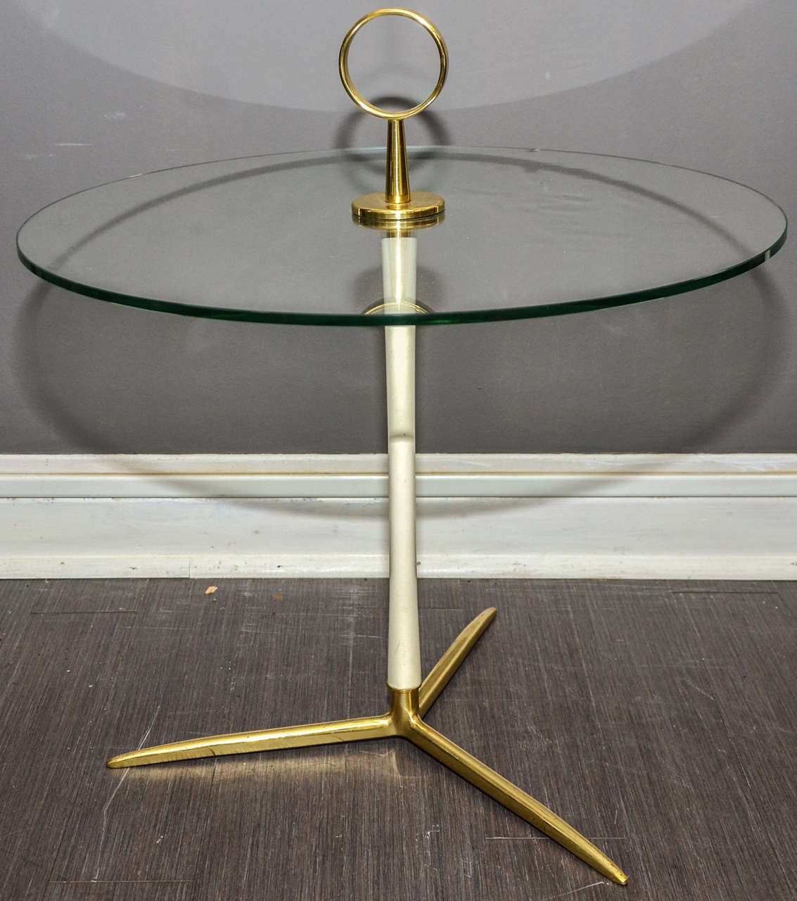 1950s Italian gueridon in gilded broze with central shaft in white patina; circular top surface. One damaged area (see view 9) on edge of glass that can be restored upon request without additional charge.