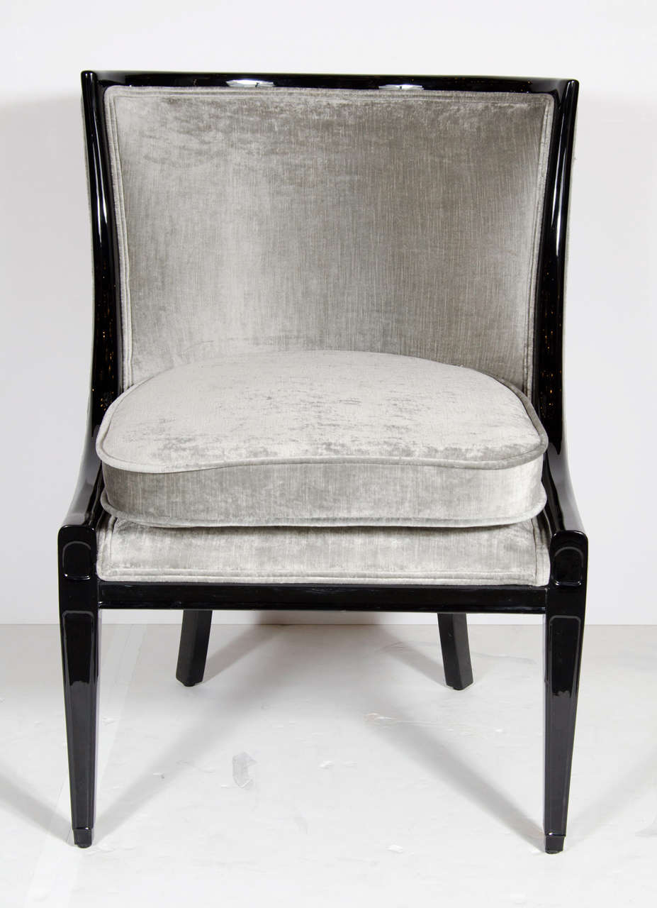 This gorgeous pair of chairs feature an ebonized walnut sculptural frame with a curved back design with stylized conical legs. They have been newly upholstered in a platinum taupe velvet.