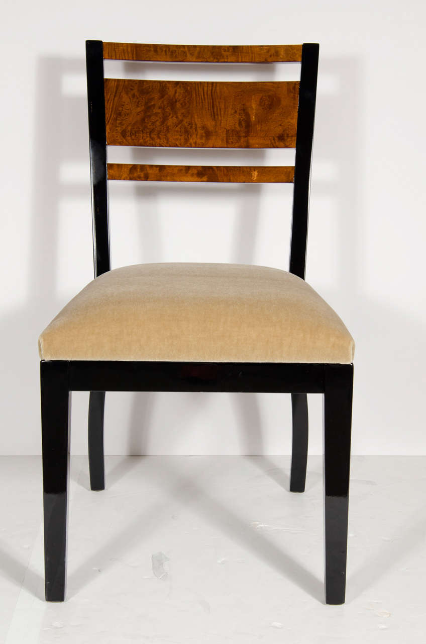 This streamline pair of  chairs feature stunning book matched burled carpathian elm back rests with a black lacquer frame and legs.Newly upholstered in a camel mohair.These chairs are by the foremost designer of the Art Deco period Donald Deskey who