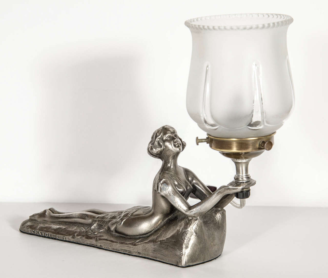 This exquisite Art Deco uplight features a silvered base in the form of a lady laying down holding and looking up at the delicate  frosted glass shade with beaded edge detail. This piece has been newly rewired and is signed Chandler T.