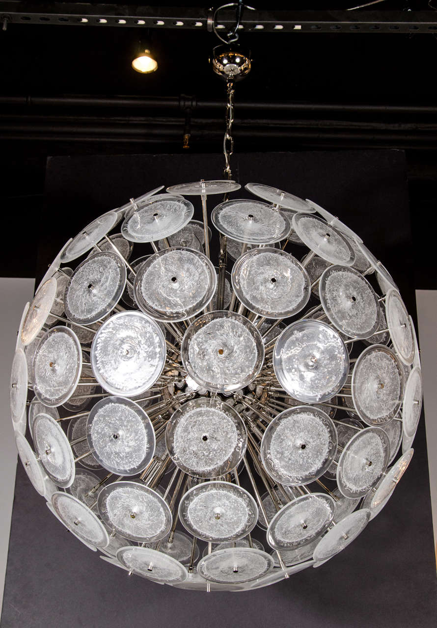 This stunning chandelier was hand blown in Murano, Italy- the island off the coast of Venice renowned for centuries for its superlative glass production. It features an abundance of hand blown textured and translucent Murano glass vistosi disks
