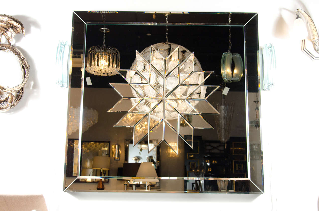 This gorgeous sculptural relief mirror features a beveled modernist chevron design applique' on a smoked mirrored backround with hand beveled borders.Not only is this a stunning mirror but it is a wall sculpture as well.Would make a stunning