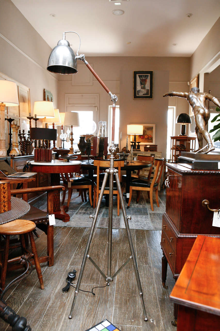 A nickel and teak tripod base adjustable floor lamp. Pair available.