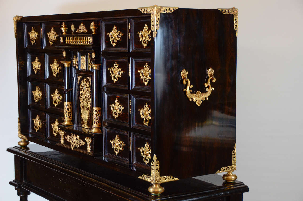 Ebony with gilt metal ,percied angles and mounts with a central cupboard containing drawers.The gilting is original and very high quality.
The stand is 19th century.