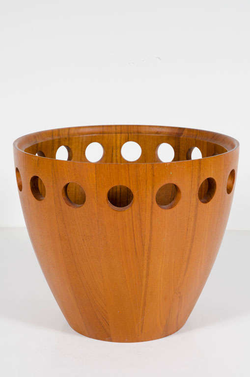 A Danish modern fruit bowl made in strips of staved teak with circles pierced around the top and an interior carved rim. Stamped to the underside 