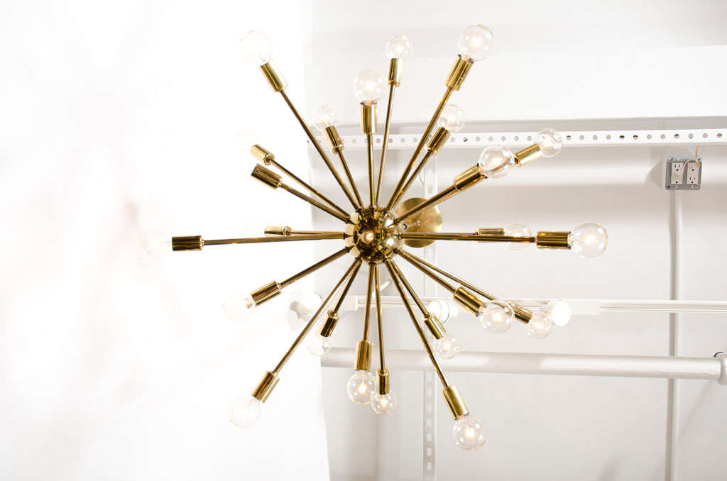 A classic sputnik form chandelier comprising a brass canopy, shaft and orb supporting an array of 24 arms terminating in a bulb socket.  American, circa 1950.