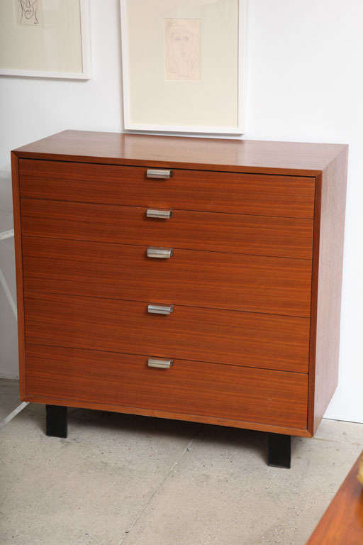 Herman Miller's BSC (Basic Storage Component #4620) Dresser was designed by George Nelson. The dresser is a walnut modular case that has five flush wood side slide drawers with original chrome-plated metal pulls (6-section divider in top drawer and