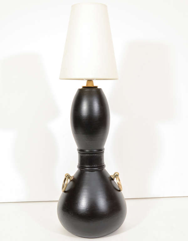Black pottery table lamp by Ugo Zaccagnini. Italy, circa 1930. Signed.  Complemented by decorative brass rings.  Rewired with French silk twist cord.  Includes shade.
