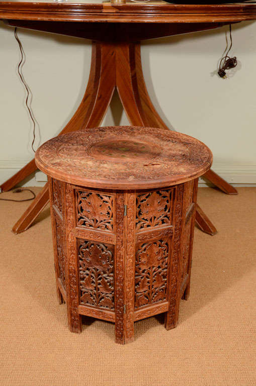 This beautifully carved mahogany side table is built like a small folding screen, hinging to change shape, with an intricately detailed and brass inlaid removable top it will serve many functions in your space.