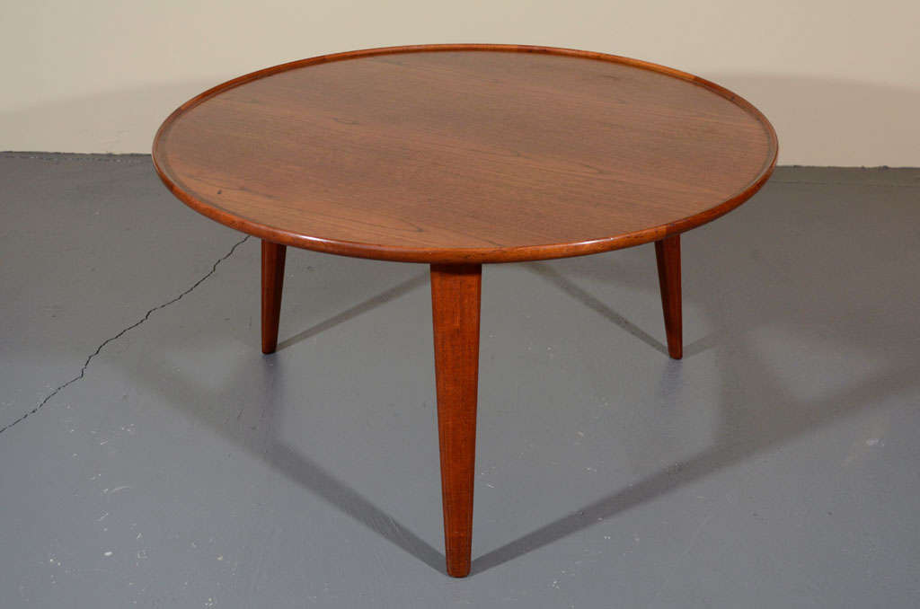 Danish teak circular table with a lipped edge raised on three circular tapered legs joined by a tripartite stretcher. Designed by Aksel Bender Madsen and Ejner Larsen. Produced by Willy Beck, Copenhagen. Labeled.