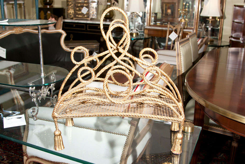A Hollywood Regency style bronze magazine rack. Fine tassle form feet leading to a inticate rope design.