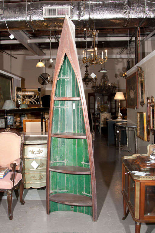 A pair of tall decorative canoes used as shelving units.