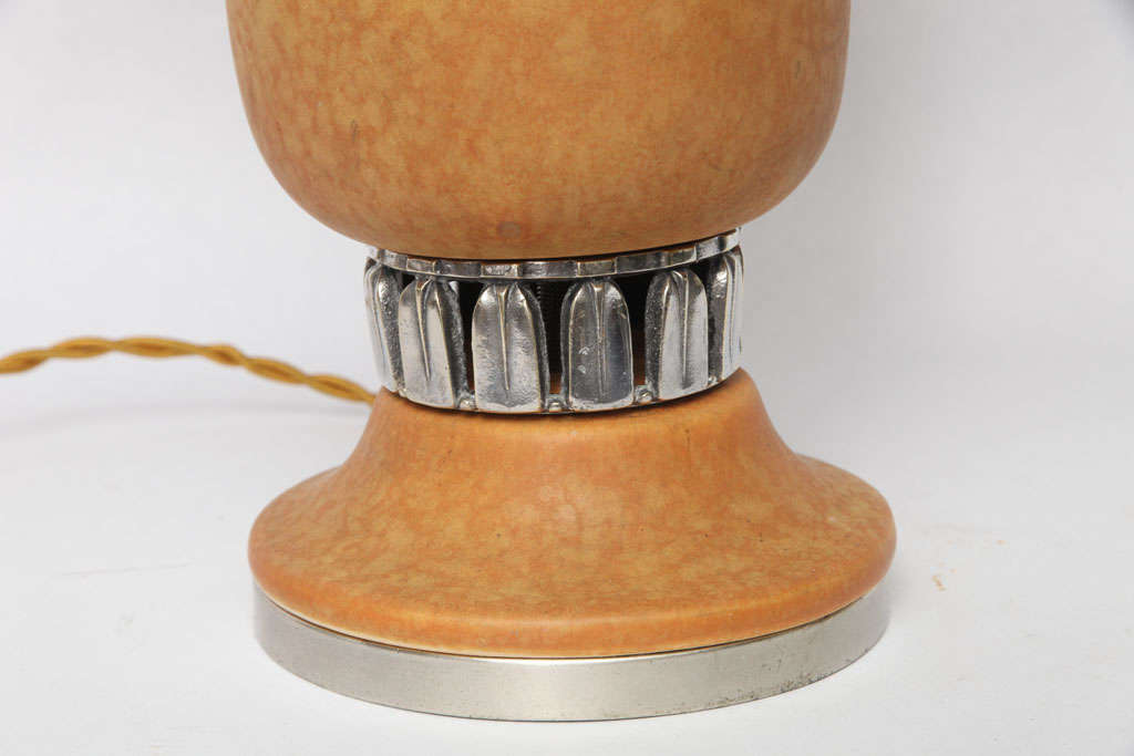 A French Art Deco ceramic table lamp with silvered metal mounts.
Shade not included