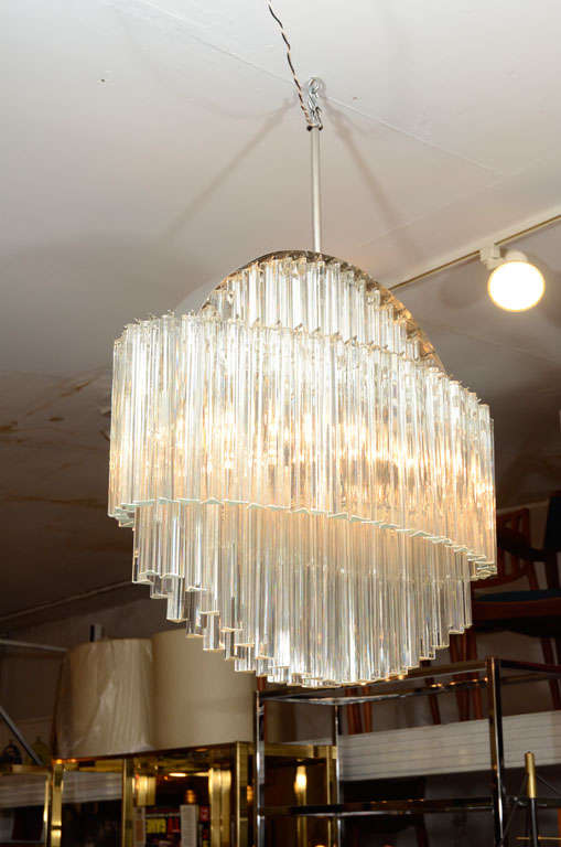 Fantastic Camer chandelier with a double chrome armature: It has a vertical circular form with hanging Murano crystals. The vertical circular armature is ringed by a horizontal oval armature with a profile of crystals. Very sparkly and showy! Please