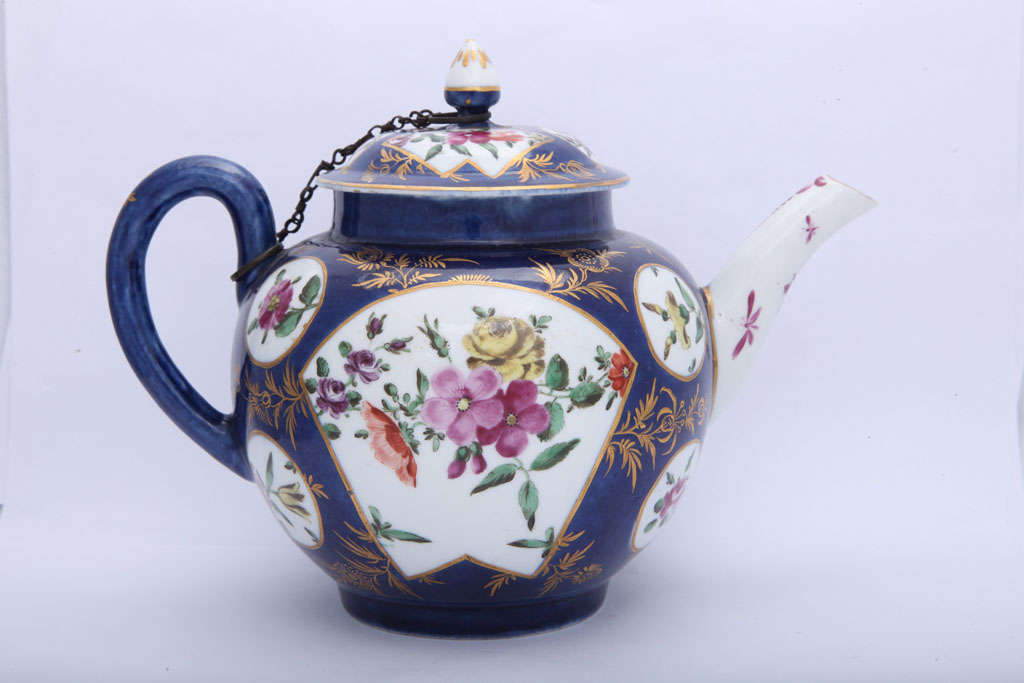 A rare First Period Worcester porcelain powder blue ground teapot decorated with English flowers within fan shape panels