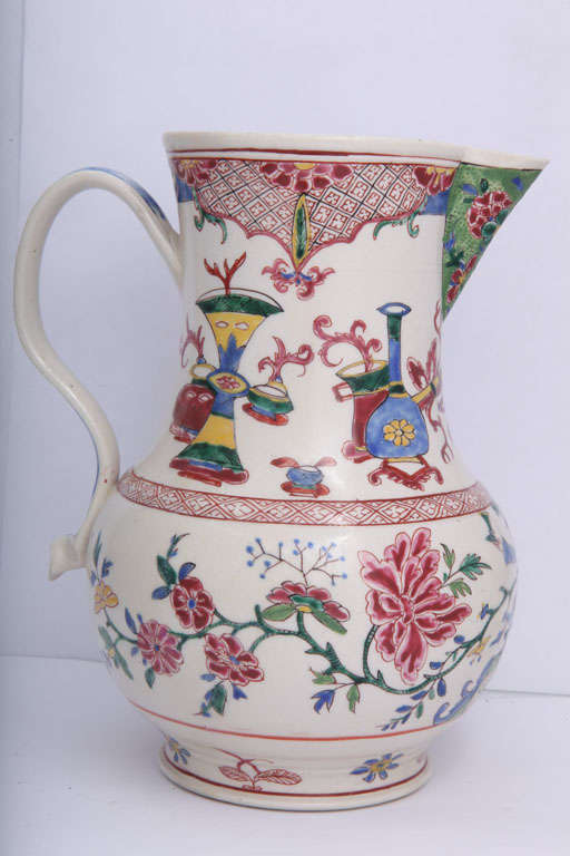 A rare English saltglazed stoneware pitcher painted with an Oriental figure, flowers and 