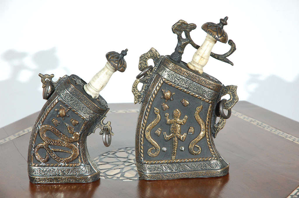 Moroccan antiques, set of two wood covered with brass and silver filigree gun powder case flask, delicately hand-hammered brass with animals decor for power protection, the top open and the neck is made of bone.

Size: small: 9