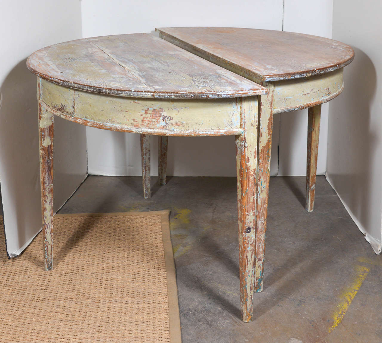Beautiful pair of demilune tables with original light green paint showing through.