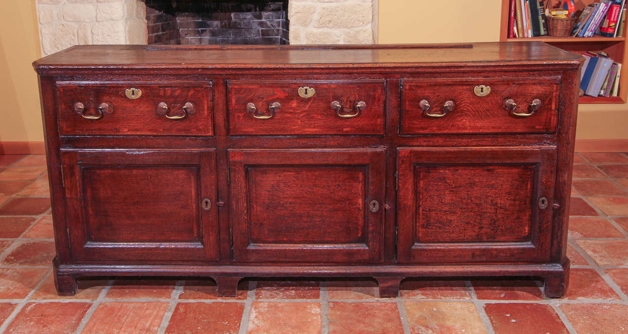 English Oak Dresser Base

Early, English oak dresser base with wonderful patina.

The top features a mahogany cross-banded edge and nice canted corners. 

There are three original dove-tailed drawers with rosette handles (bail pull) that are