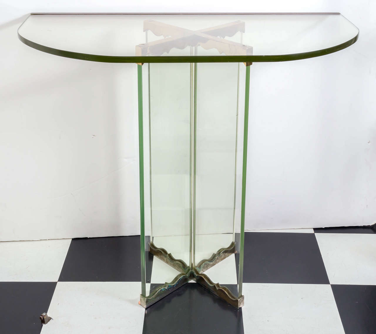 Moderne glass and brass trimmed console table. Heavy plate glass, circa 1940. Heavy castings on the two piece glass base. Greenish glass to clear color. Green in the glass related to the iron content and to adds strength.
In the manner of Fontana
